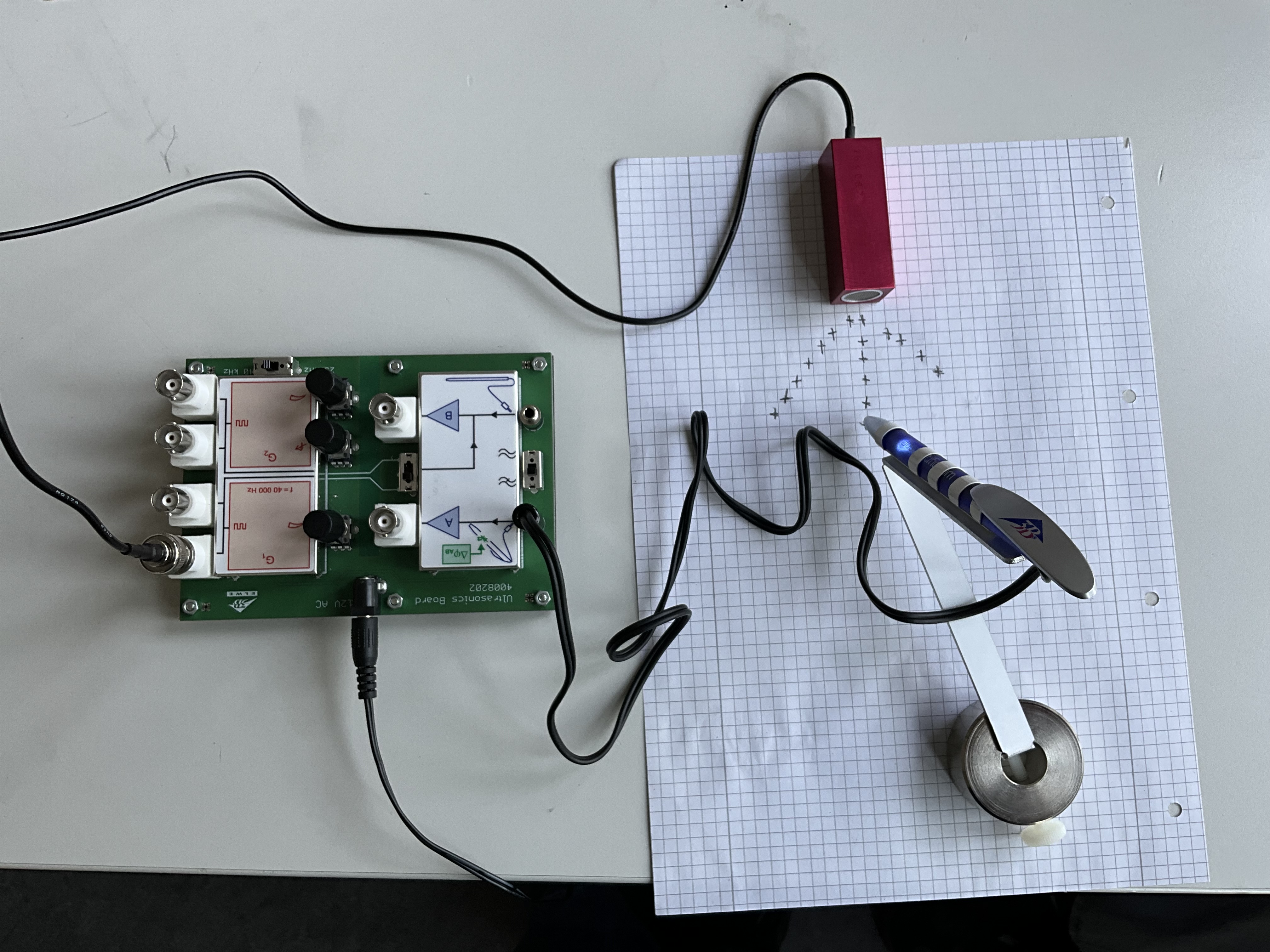 Ultraschall-Sender und Empfängerstift auf Millimeterpapier