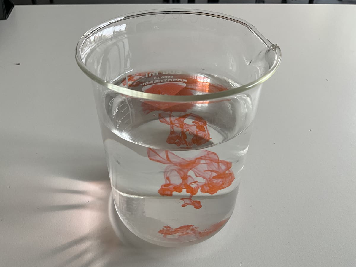 Die Farbe zieht Schlieren durch das Wasser